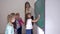 Pupils and teacher standing near whiteboard in classroom, schoolgirl takes piece of chalk and writes answer at the