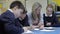 Pupils Working At Table With Teacher Helping Them