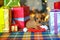 Puppy dachshunds sitting near gifts and playing with Santa`s cap, bright festive garlands in the background