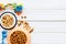 Puppy dry food in bowl and toys on white wooden background top view copyspace