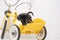 Puppy portrait Jack Russell Terrier in the back of a yellow tricycle on a white background