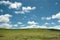 Pure blue sky with write clouds over a meadow