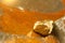 The pure gold ore found in the mine on a wet stone by the river. Golden bar in nature with shiny sunlight close up.