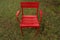 Pure Red empty furniture chair on green grass.