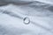 Pure water droplet shining in the light on white fabric with folds