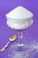 Pure White Granulated Sugar in a Vintage Glass on a Purple Background
