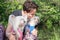 Purebred Chinese Crested dogs in harnesses sit on their owner`s lap