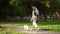 Purebred pug running in the park with dreadlocks female owner leading the leash in summer