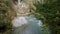 Purest mountain creek in the forest. Stream of water moves between the stones covered with moss. Small river with rocks