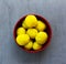 Purified boiled yellow potatoes in a red bowl on a gray background