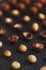 Purified and shell repeats macadamia nuts on black textural stone background. Healthy eating concept. Low contrast