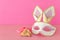 Purim celebration concept jewish carnival holiday with cute rabbit mask, noisemaker and hamantash cookies over wooden table