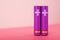 Purple AA batteries on a pink table