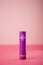 Purple AA battery on a pink table