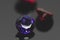 Purple amethyst gemstone and red rubies on black reflective surface