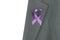 A purple awareness ribbon on the lapel of the jacket