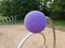 Purple ball or sphere and metal pole and wood chips on playground