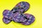 Purple Beach Day Flip Flops with dragonfly pattern isolated on bright yellow