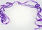 Purple beads and ribbon and sparkly jewels on a light background make a border for International Women`s Day on March 8th each