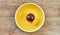 Purple bulb of red sweet onion on a yellow plate on a wooden tabletop