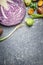 Purple cabbage and vegetables ingredients for cooking on gray rustic background, top view. Vegetarian and health food concept
