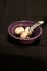 Purple, ceramic bowl with three white mushrooms