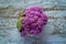 Purple color cauliflower vegetable on a gray table