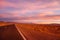 Purple colored magical sunset. desert road in a mountainous region