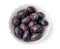 Purple damson plums in bowl top view isolated