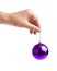 Purple decoration xmas ball in female hand, isolated on white