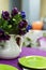 Purple dining table with green plates.