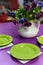 Purple dining table with green plates.