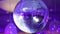 Purple disco ball reflecting the rays into the background of balloons. Close up