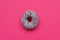 Purple donut decorated colorful sprinkles on pink background. Flat lay. Top view. Unhealthy food