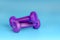 Purple dumbbells for sports on a blue background