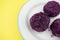 Purple dumplings with plums on yellow background