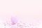 Purple easter eggshell on pastel pink background with colorful confetti. Egg is a symbol of the celebration of a religious holiday