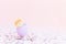 Purple easter eggshell with yellow,orange,beige pastel small rose on pink background, multicolor confetti. Egg is symbol of