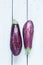 Purple eggplant (aubergine) on white planked wood table from above