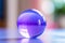a purple glass ball sitting on a table
