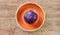 Purple head of red cabbage on a orange plate on a wooden tabletop