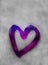 Purple heart outline painted on sweaty glass, many drops on it, inscription heart and love handmade on wet autumn foggy glass