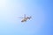 Purple helicopter tour flies against background of clear blue sky. Photo of a flying vehicle with blurred rotating blades