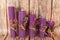 Purple honey candles handmade from natural wax on a background of wooden boards. Elements from natural materials