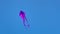 Purple kite is flying in the blue sky during summer outdoor festival
