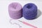 Purple knitting and crochet threads on a white isolated background. Leisure time hobby and handicraft concept