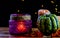 Purple lantern, green pumpkin rowan berries and candle on wooden rustic table and black background with yellow bokeh dots,