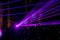 Purple laser neon beams. Crowd of people watching laser show at street festival.