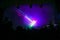 Purple laser neon beams. Crowd of people watching laser show at street festival.