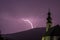 Purple lightning storm with church in foreground